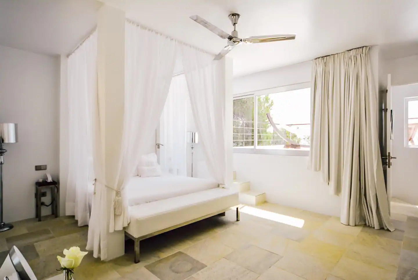 A cozy and inviting bedroom with warm lighting, a plush bed adorned with soft blankets